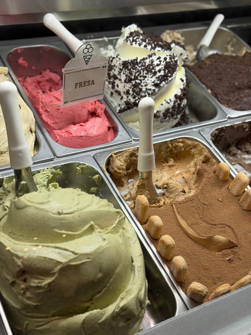 Vitrina con sabores de gelato: fresa, pistacho y tiramisú