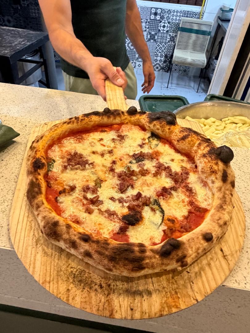 Pizzaiolo sirviendo una pizza recién hecha